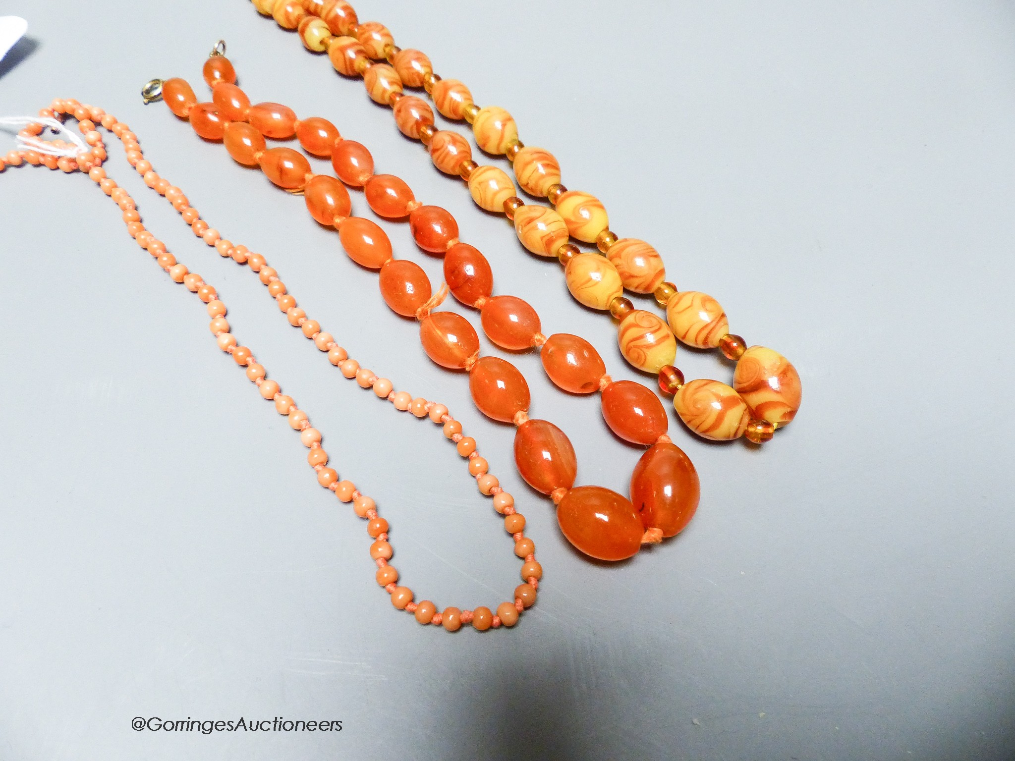 A coral bead necklace, 47cm and two other necklaces.